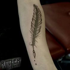 a black and white feather tattoo on the arm