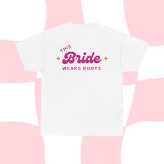 The perfect t shirt for the bride's last rodeo! This t shirt has a large western design on the back and small pink "Bride" on the front.  Product features - Shoulder tape for stability - Knitted in one piece without side seams - Ribbed knit collar for elasticity - Made from specially spun fibers for strong and smooth fabric - Classic fit for comfy wear and tear-away label for scratch-free experience Care instructions - Machine wash: warm (max 40C or 105F) - Tumble dry: medium - Do not iron - Do Cowgirl Bride, Pink Bride, Western Cowgirls, Western Design, Hen Do, Cow Girl, Bride Wear, Engagement Gifts, Rodeo