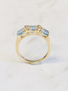 "14kt Yellow Gold Lady's Three Gemstone Oval Blue Topaz Ring consisting of 3- 6mm x 4mm genuine Oval Blue Topaz Gemstones all prong set with an \"X\" of Gold in between each oval Gemstone. This is a \"0X0X0\" Hugs and Kisses Ring. The finger size is 7. This item would Retail for $ 595.00" Yellow Gold Blue Topaz Baguette Cut Ring, Yellow Gold Baguette Cut Blue Topaz Ring, Blue Topaz Baguette Cut Ring In Yellow Gold, Baguette Cut Blue Topaz Ring In Yellow Gold, Blue Topaz Three Stone Ring For Anniversary, Three-stone Blue Topaz Ring For Anniversary, Three Stone Blue Topaz Ring For Anniversary, Classic Topaz Ring With Round Cut, Classic Topaz Ring