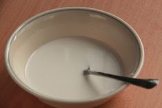 a bowl of milk with a spoon in it