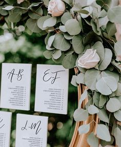 the seating cards were placed on top of each other with greenery and flowers around them