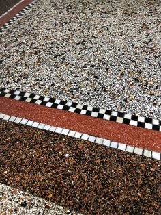 a black and white checkered skateboard laying on the ground next to a curb