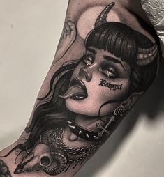 a woman's arm with a tattoo on it and an image of a demon