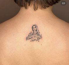 the back of a woman's neck with a tattoo on her left shoulder and an image of jesus