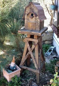 a bird house sitting on top of a wooden stand