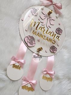 a mirror with some pink ribbon around it and two tags attached to the mirror that says, mamama manzanno