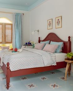 a bed room with a neatly made bed next to a small table and window sill