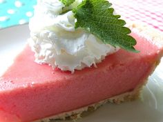 a piece of pie with whipped cream and mint on top is sitting on a plate