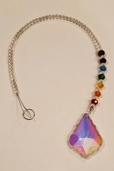 a multicolored necklace is hanging from a silver chain