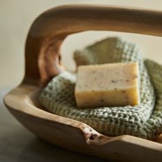 a wooden bowl filled with soap on top of a table