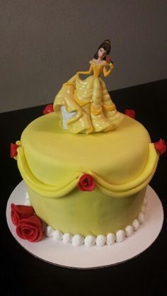 there is a cake that has been decorated with a princess on top and roses around the edges