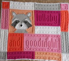 a crocheted blanket with a raccoon on it's face and name