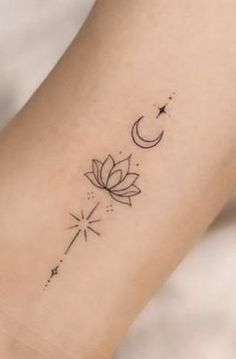 a small lotus tattoo on the ankle with a star and moon in the sky above it