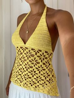 a woman wearing a yellow crochet halter top