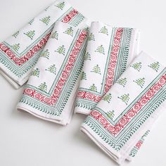 three white towels with red and green designs on them