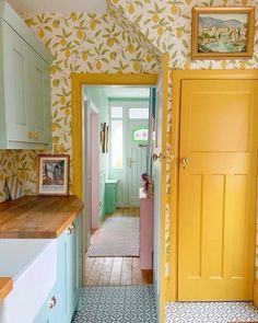 an open door leading to a kitchen with blue and yellow wallpaper on the walls