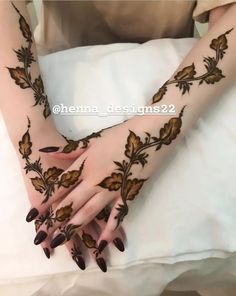 a woman's hands with henna designs on them