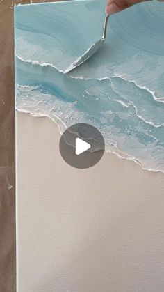 someone is painting waves on the wall with acrylic paint and using a brush