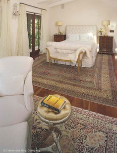 a bedroom with a bed, chair and rug in it's centerpieces