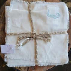 two napkins tied together with twine and rope on top of a wooden table