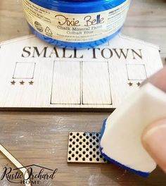 someone is stamping the word small town on a piece of wood