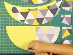 someone is cutting out geometric shapes on a piece of paper