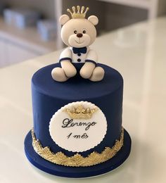 a blue cake with a teddy bear on top that says george i am souvenir