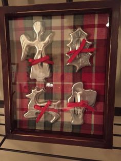 some cookies are in a glass frame with red ribbon around them and an angel on top