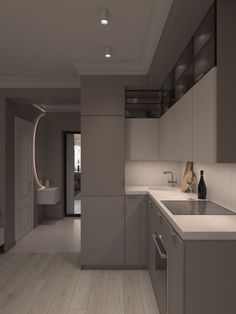 an empty kitchen with white counter tops and wooden flooring is shown in this image