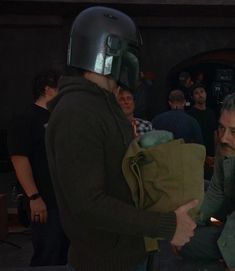 a man in a helmet is holding a bag while other people are standing around him