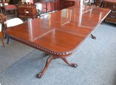 a large wooden table sitting on top of a blue carpeted floor