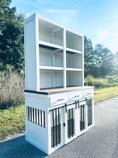 a large white bookcase sitting on the side of a road