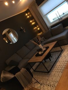 a living room filled with furniture and a large mirror on the wall above it's windows