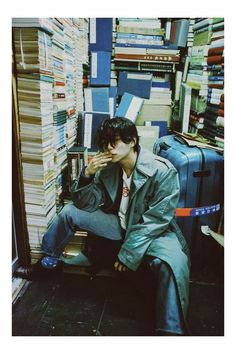 a man sitting on the floor in front of a pile of books