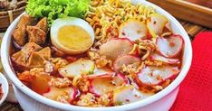 two bowls filled with food sitting on top of a table next to chopsticks