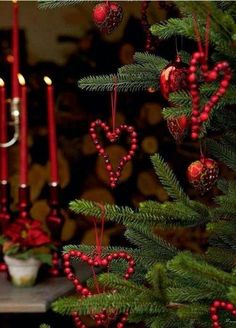 a christmas tree with candles and ornaments hanging from it