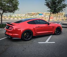 a red mustang parked in a parking lot