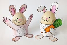 two wooden rabbits holding carrots on white background