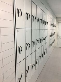 the lockers are lined up against the wall with black handles and hooks on them