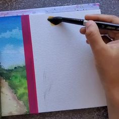 someone is painting a landscape with watercolors