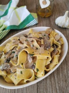 a white plate topped with pasta covered in mushroom sauce