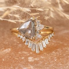 a close up of a diamond ring on a table with dried grass in the background