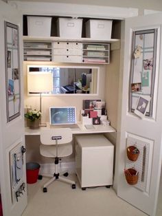 a home office area with desk, computer and storage bins on the door way