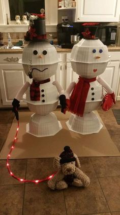 two snowmen standing on top of a kitchen floor