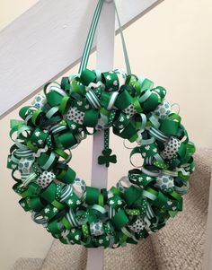 a wreath with green bows and shamrocks hanging from the side of a stair rail