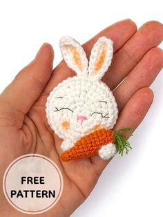 a small crocheted bunny with a carrot on its nose is in someone's hand