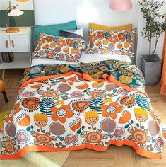 a bed with orange and blue comforters in a room