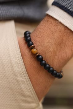 Matte Black Onyx with Matte Tiger Eye  Bracelet, Balance Bracelet, Mens Bracelet, Stretch Bracelet, Gemstone Bracelet, Healing Bracelet,Men gifts    Discover the powerful combination of Matte Black Onyx and Tiger Eye in our Men's Bracelet. This balance bracelet, crafted with gemstone healing properties, is the perfect gift for men. Matte Black Onyx is known for its grounding and protective qualities. It helps to absorb negative energy, promote emotional stability, and enhance self-control. Cube Tiger Eye, with its captivating golden-brown hues, is a stone of courage and strength. It promotes confidence, clarity, and a balanced approach to life. When these two gemstones are combined, they create a harmonious synergy. The Matte Black Onyx and Cube Tiger Eye Men's Bracelet not only adds a sty Onyx Bracelets With Natural Stones For Gift, Onyx Bracelets With Natural Stones As Gifts, Hand-strung Onyx Bracelets As A Gift, Black Spiritual Bangle Jewelry, Spiritual Black Bangle Jewelry, Spiritual Onyx Bracelets With Natural Stones, Onyx Natural Stones Bracelets, Onyx Bracelets With Natural Stones, Black Gemstone Beads Bracelets For Jewelry Making