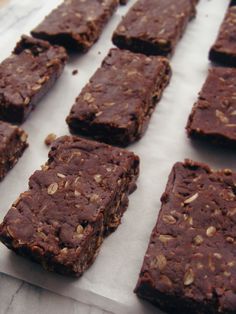 several pieces of brownie sitting on top of a piece of parchment paper