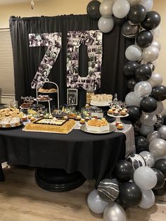 a table topped with lots of desserts next to a black and white number sign